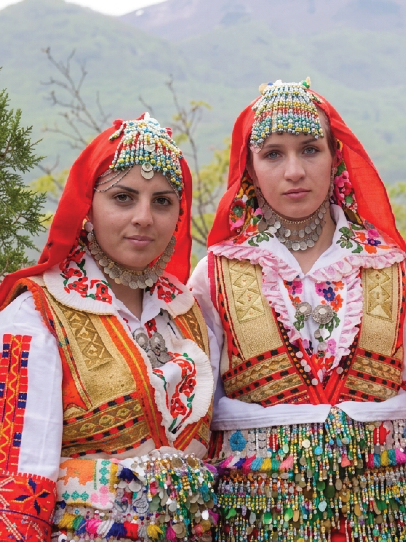Two women in richly ornamented traditional dress