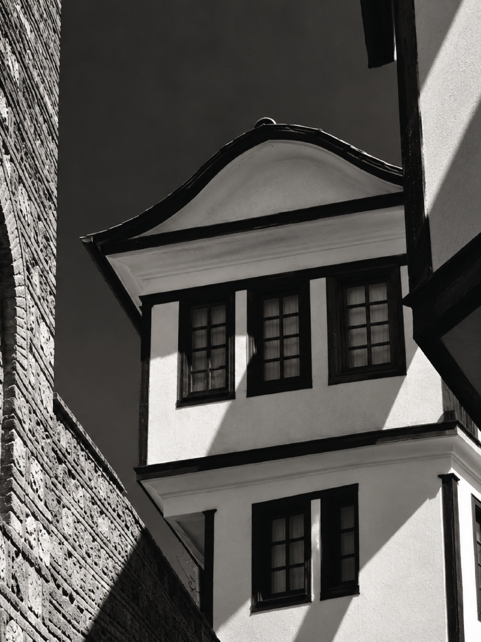 Watercolor illustration of a traditional Ohrid house on a stone street.