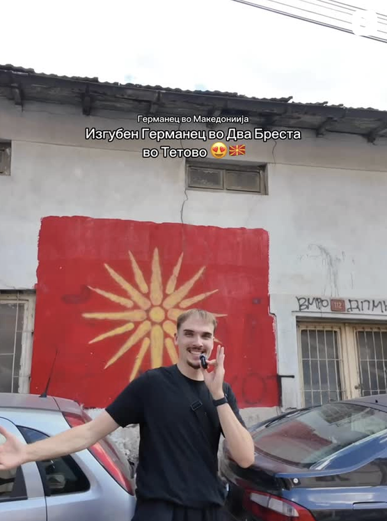 Finn Wattchow standing in front of a painted Macedonian flag in a social media video screenshot.