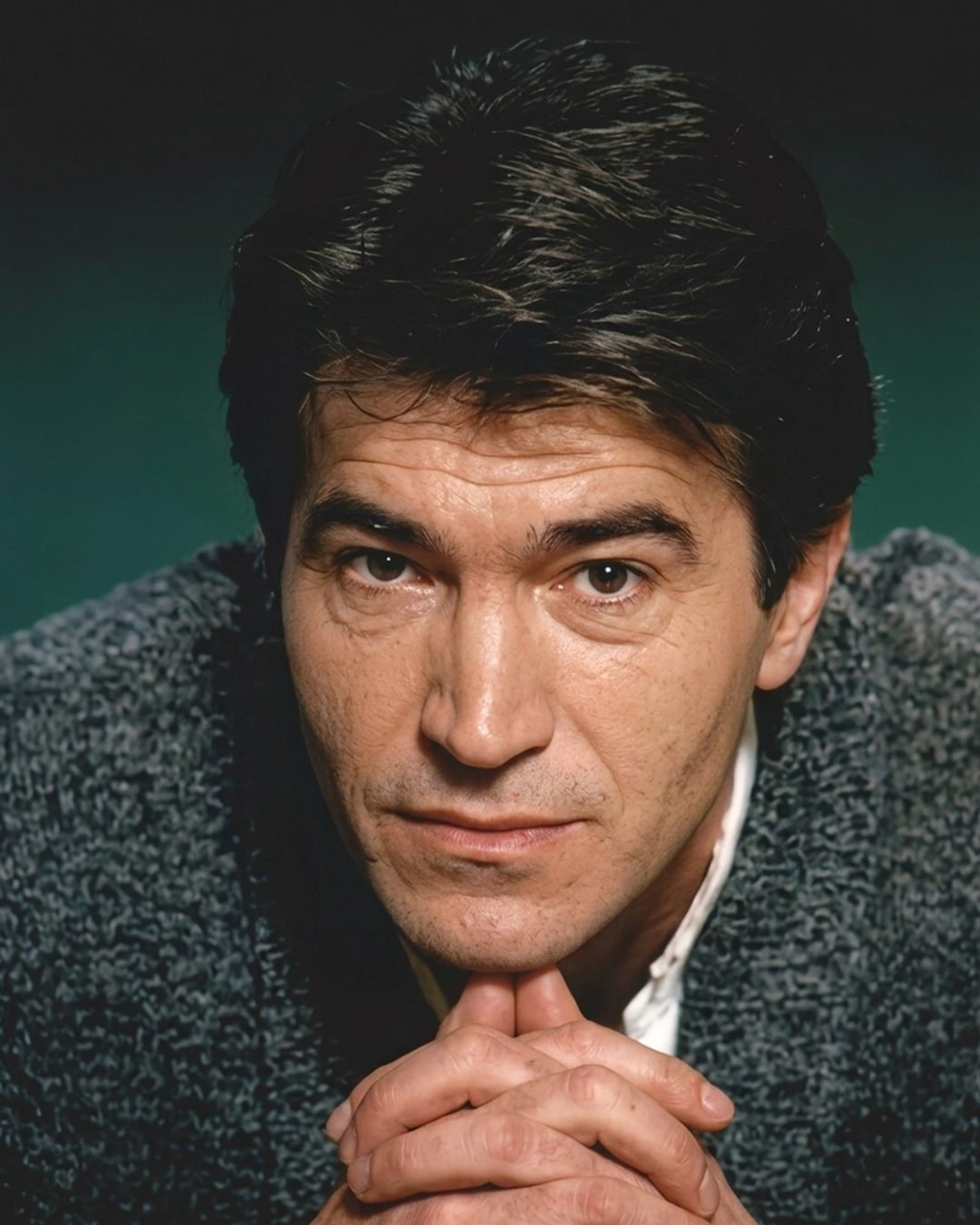 Portrait of a young Vlado Janevski resting his chin on his folded hands